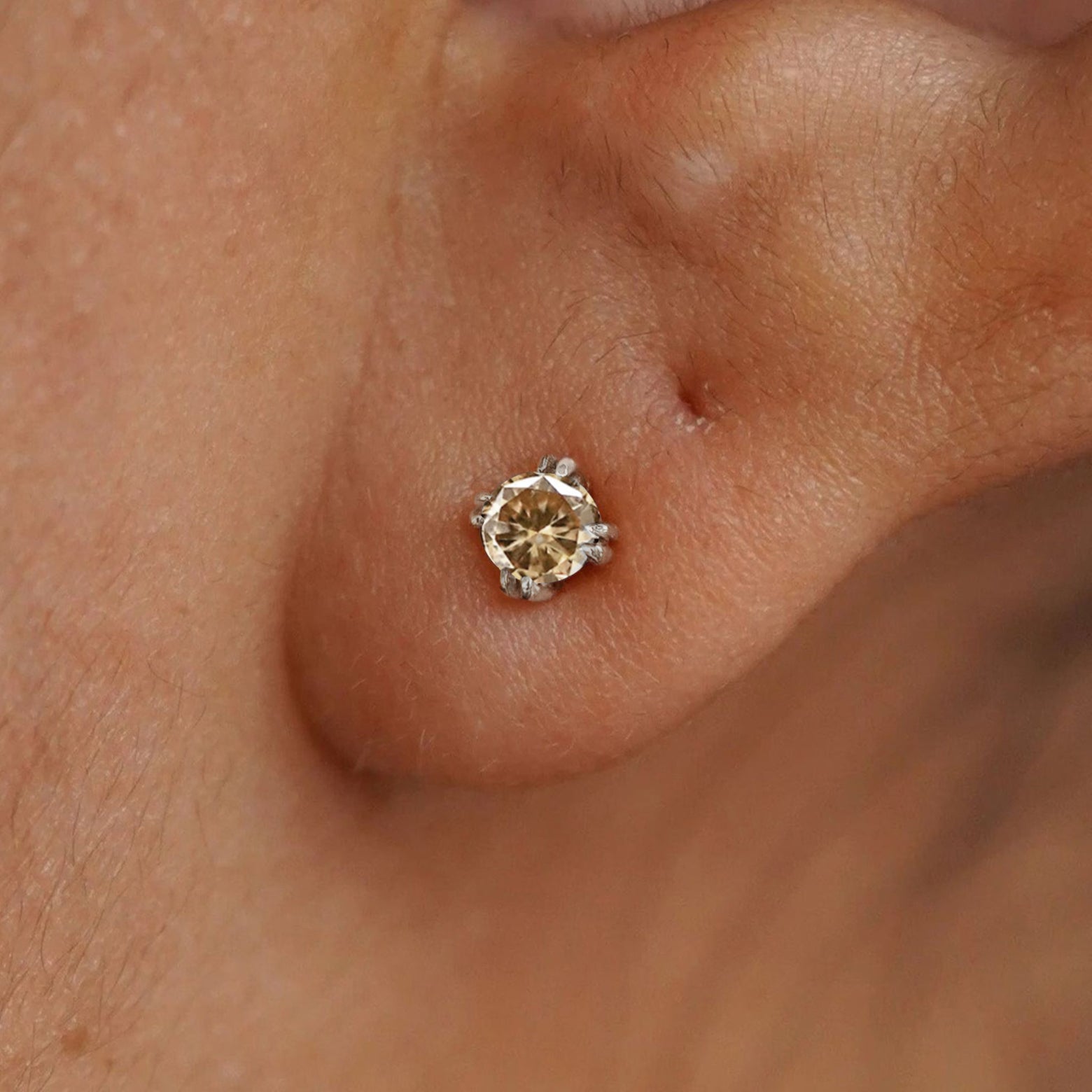 A model's ear wearing a 14k white gold Champagne Diamond Earring