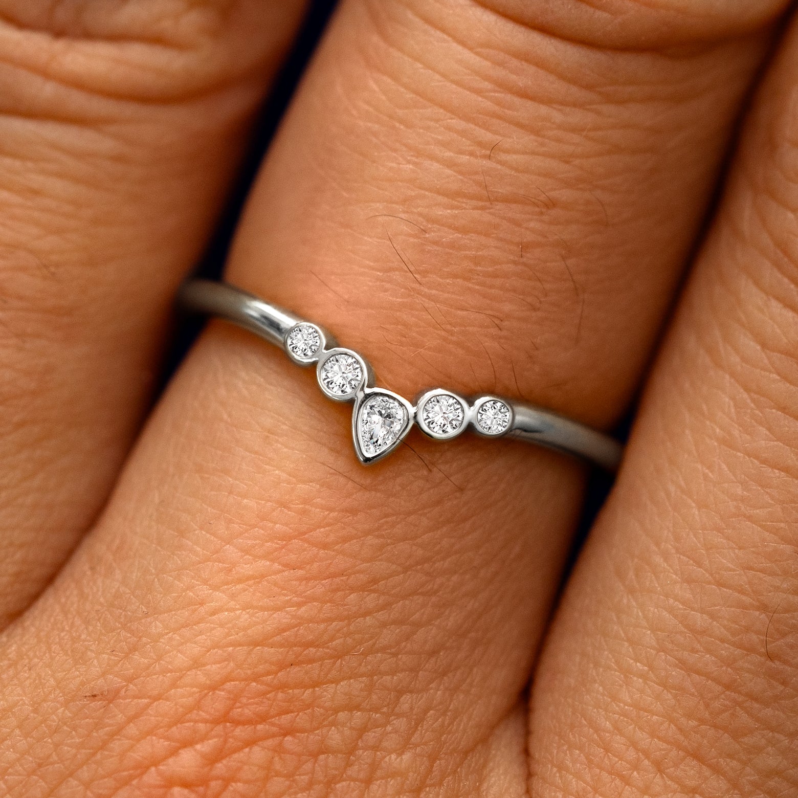 Close up view of a model's fingers wearing a 14k white gold Chevron Tiara Diamond Band