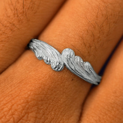 Close up view of a model's fingers wearing a 14k white gold Crashing Waves Band