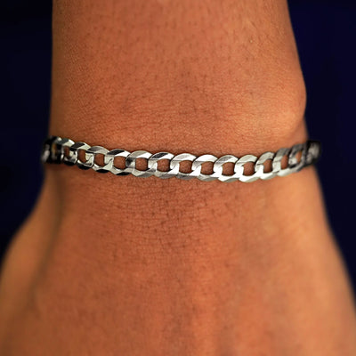 A model's wrist wearing a yellow gold Curb Chain Bracelet