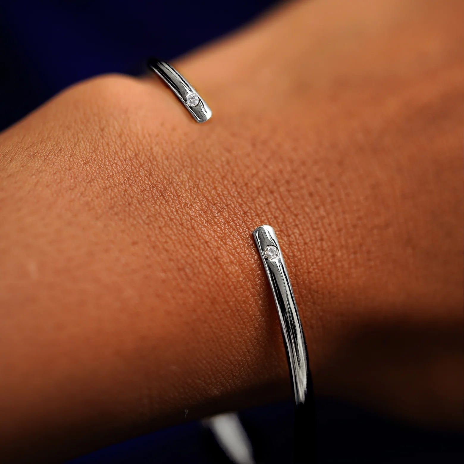 A model's wrist wearing a white gold Diamond Open Bangle Bracelet