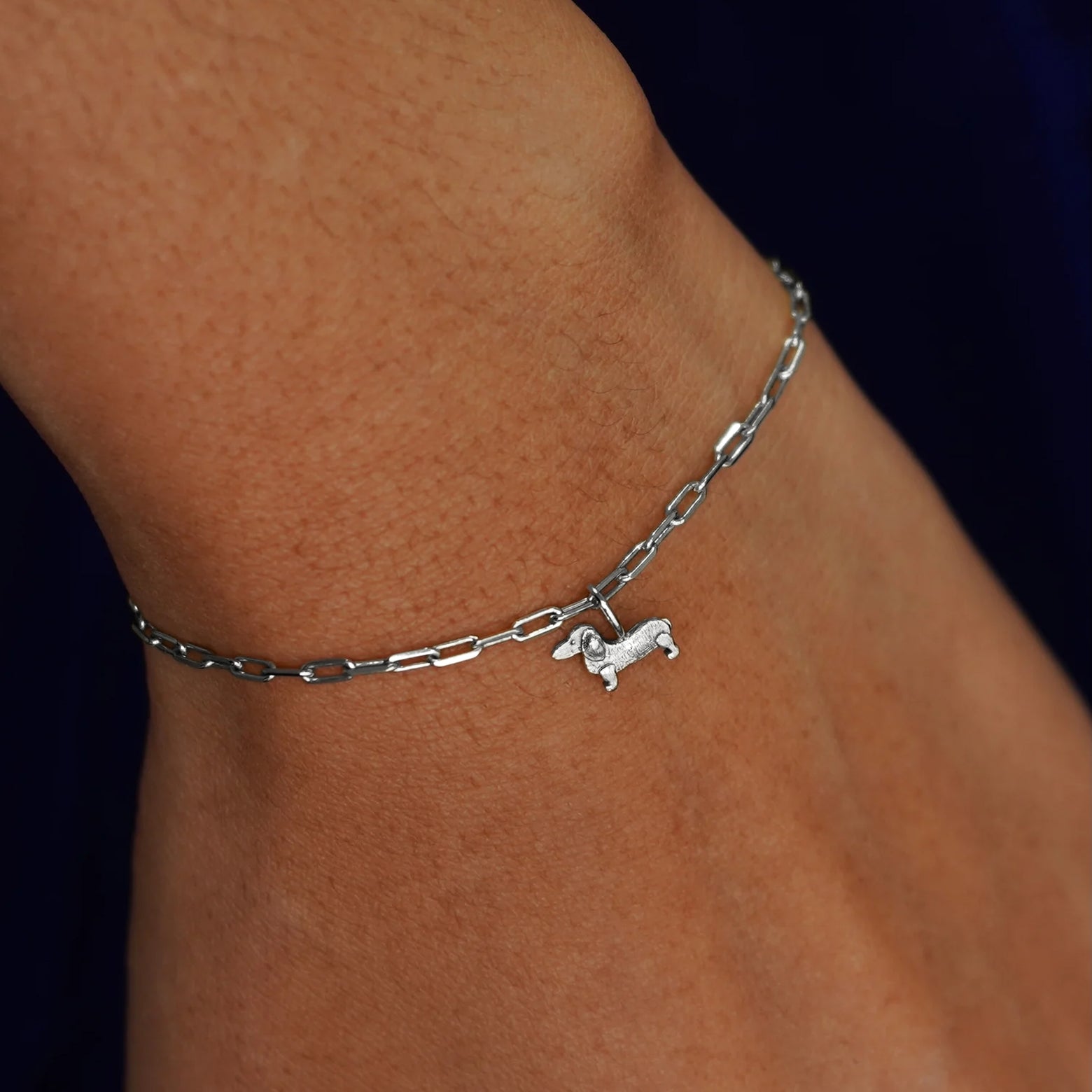 Close up view of a model's wrist wearing a white gold Infinity Dog on a Butch Bracelet