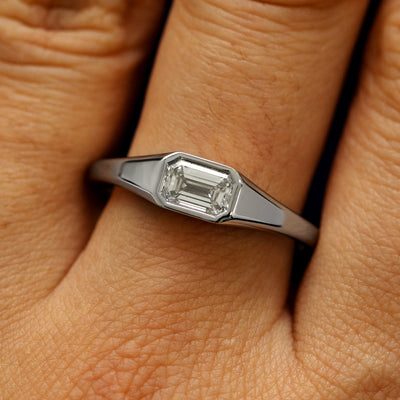 Close up view of a model's fingers wearing a 14k white gold Emerald Cut Lab Created Diamond Signet Ring