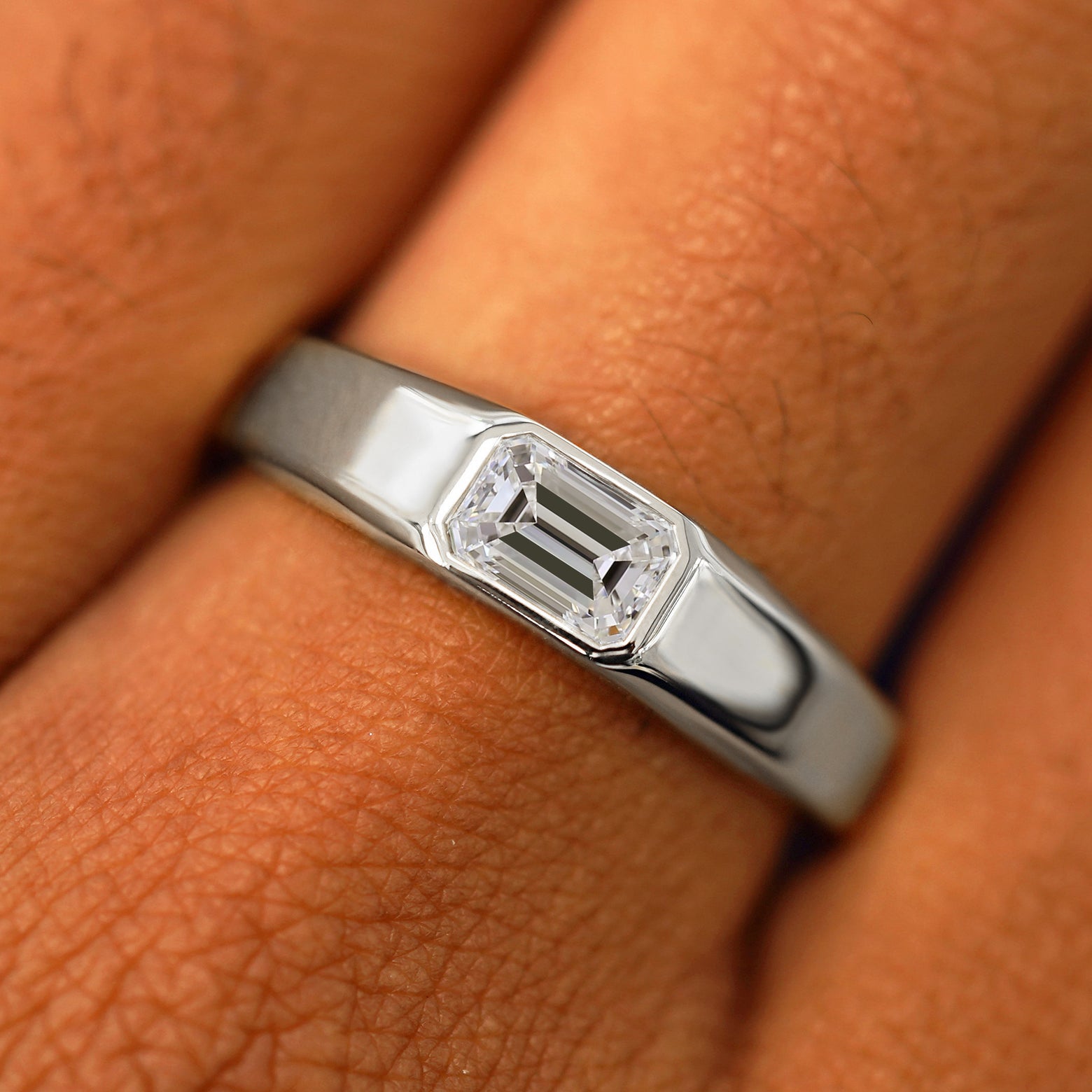 Close up view of a model's fingers wearing a 14k white gold / platinum Emerald Cut Lab Created Diamond Signet Ring