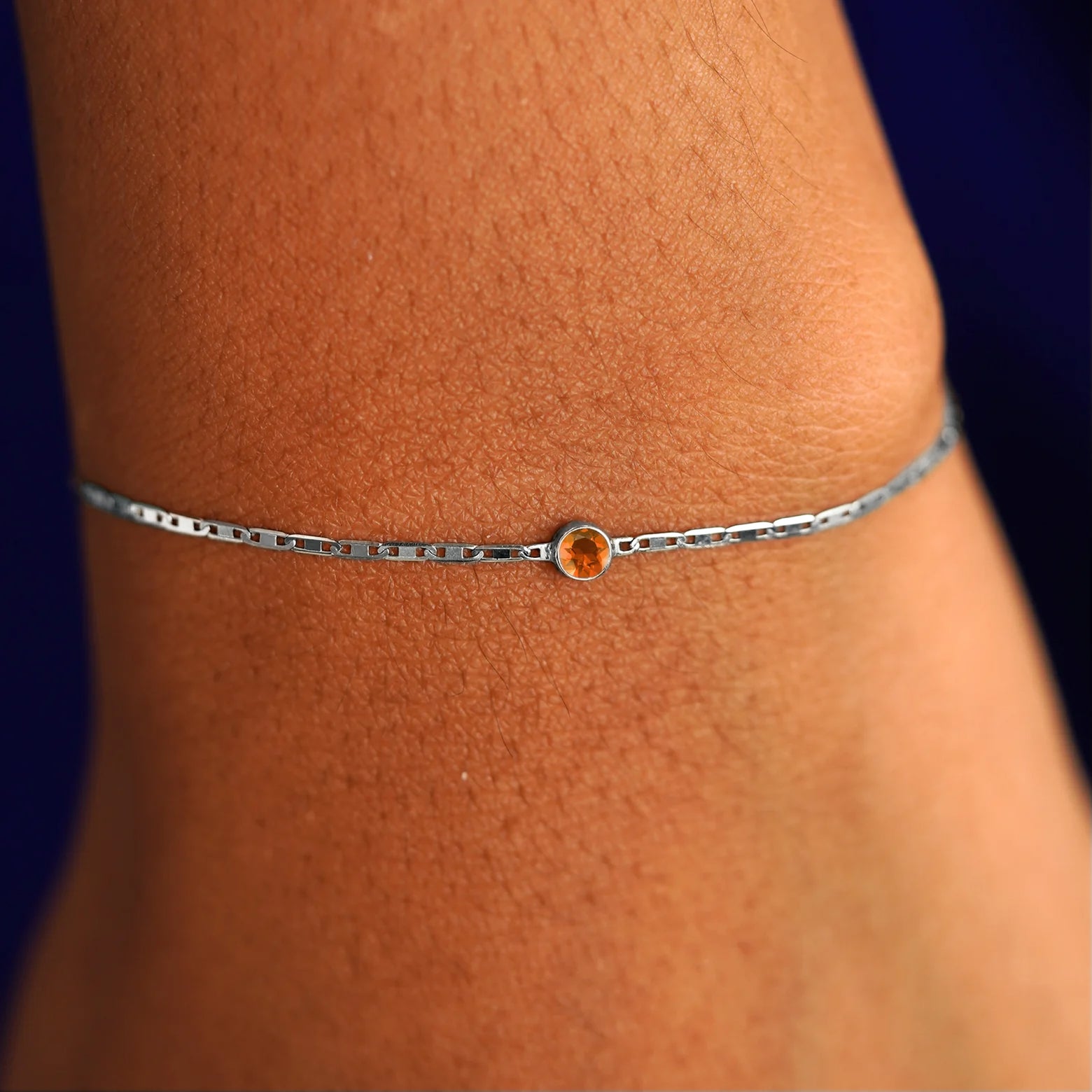 A model's wrist wearing a 14 karat white gold Fire Opal Bracelet