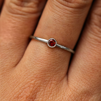Close up view of a model's fingers wearing a 14k white gold Garnet Ring