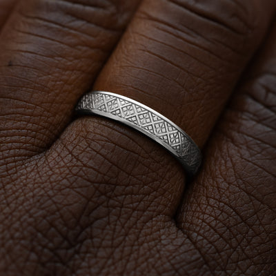Close up view of a model wearing a solid 14k white gold diamond patterned band