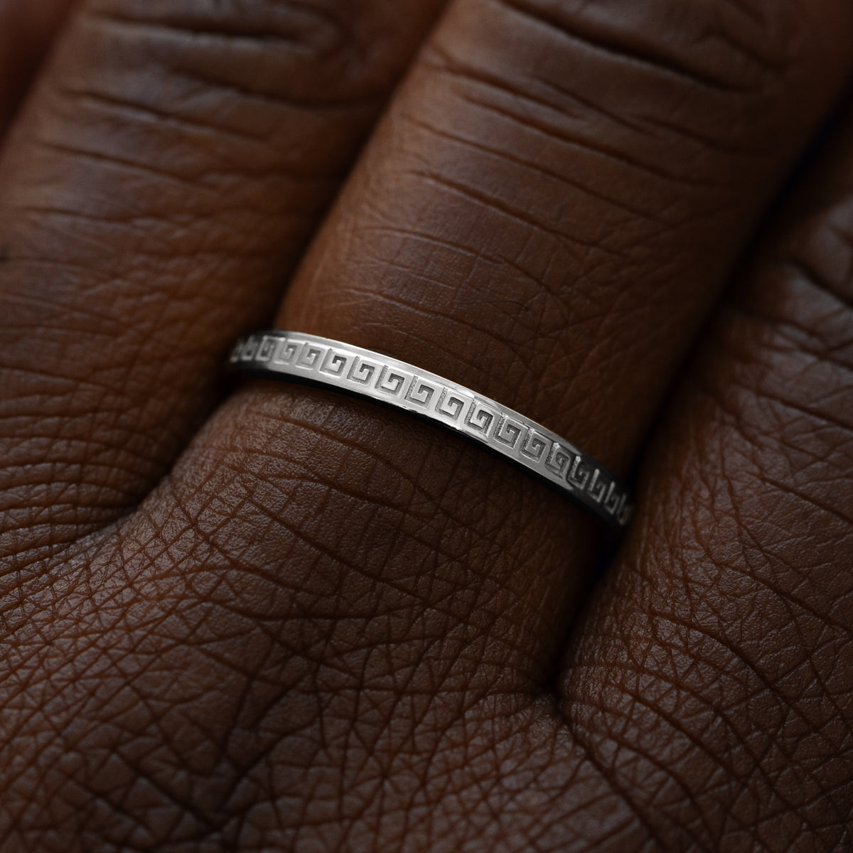 Close up view of a model wearing a solid 14k white gold geometric grass band