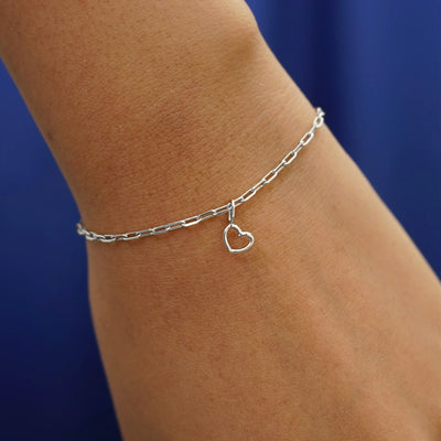 Close up view of a model's wrist wearing a white gold Heart Charm on a Butch Bracelet