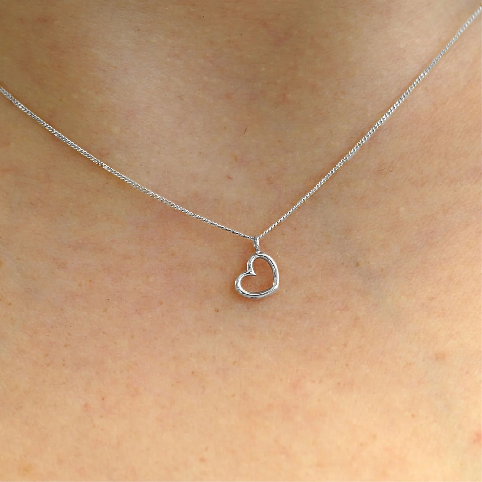 Close up view of a model's neck wearing a 14k white gold Heart Necklace