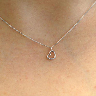 Close up view of a model's neck wearing a 14k white gold Heart Necklace