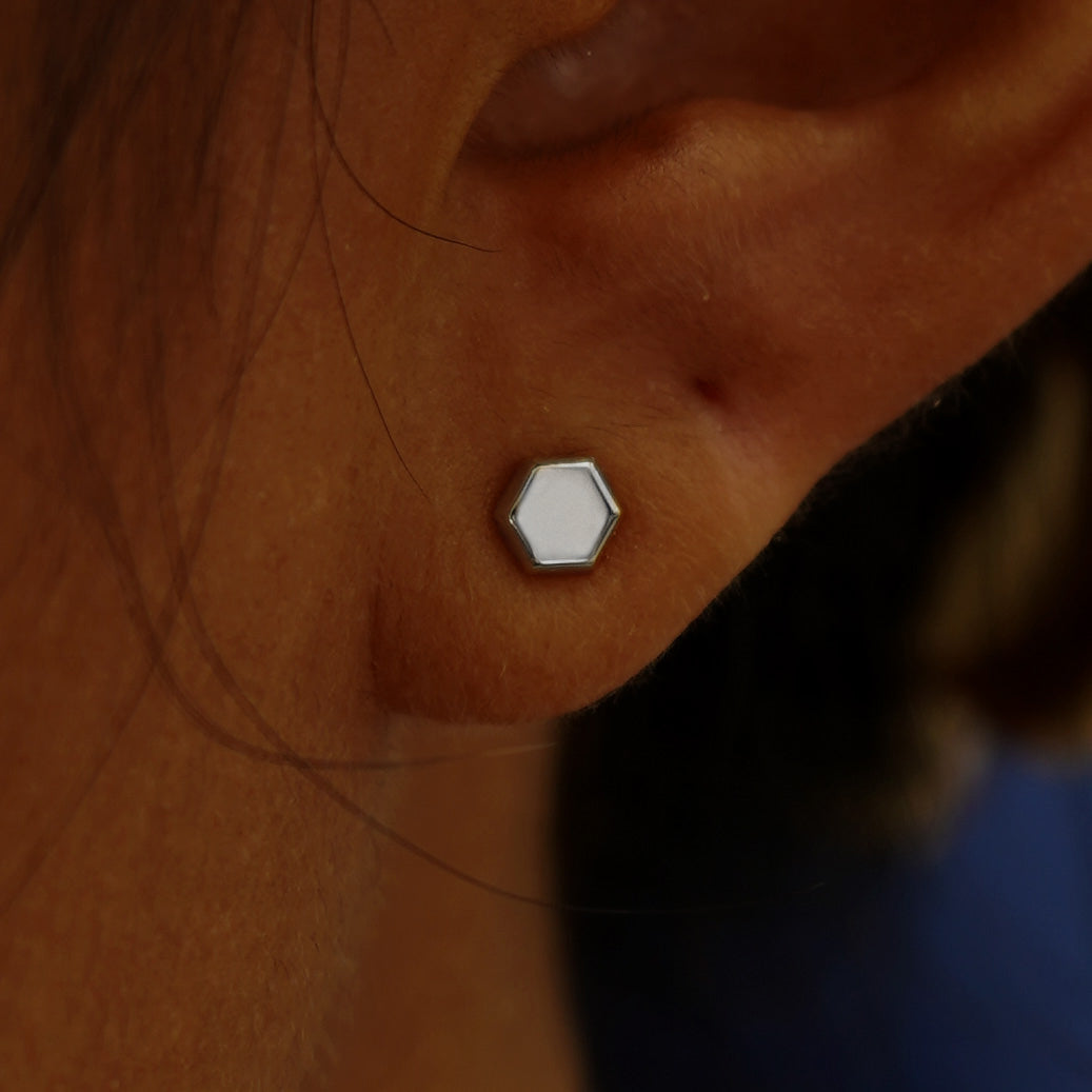 Close up view of a model's ear wearing a white gold Hexagon Earring