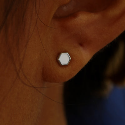 Close up view of a model's ear wearing a white gold Hexagon Earring