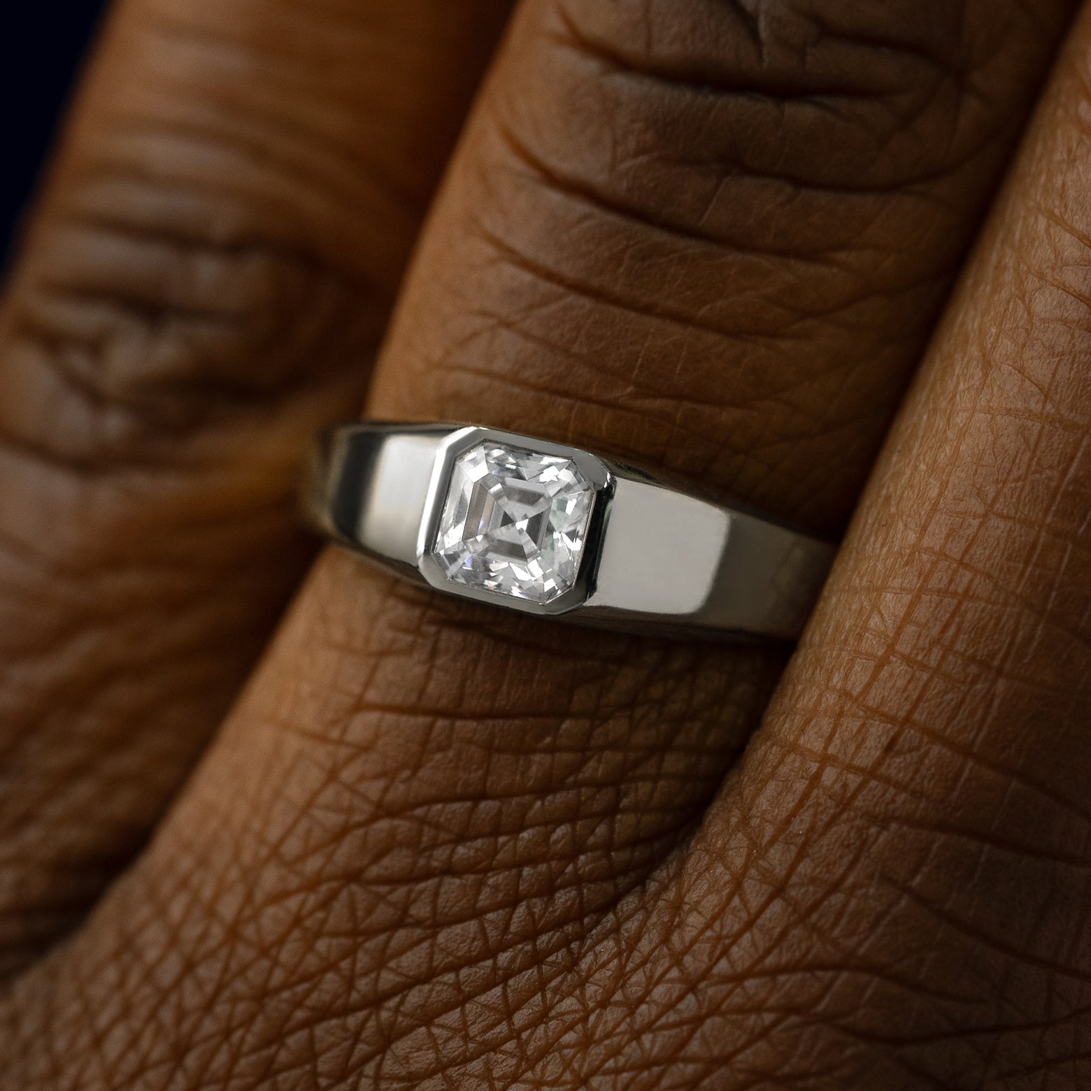 Close up view of a models hand wearing a 14k white gold asscher lab gemstone ring