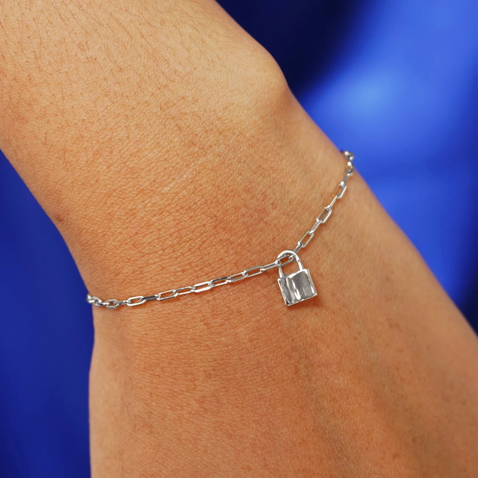 Close up view of a model's wrist wearing a white gold Lock Charm on a Butch Bracelet