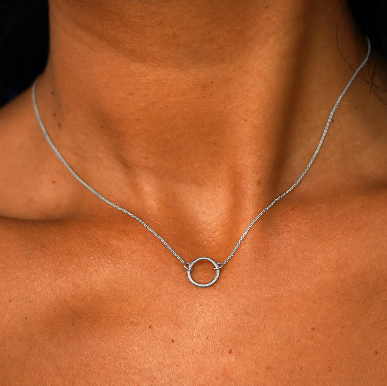 Close up view of a model's neck wearing a solid 14k white gold Lockless Cable Necklace