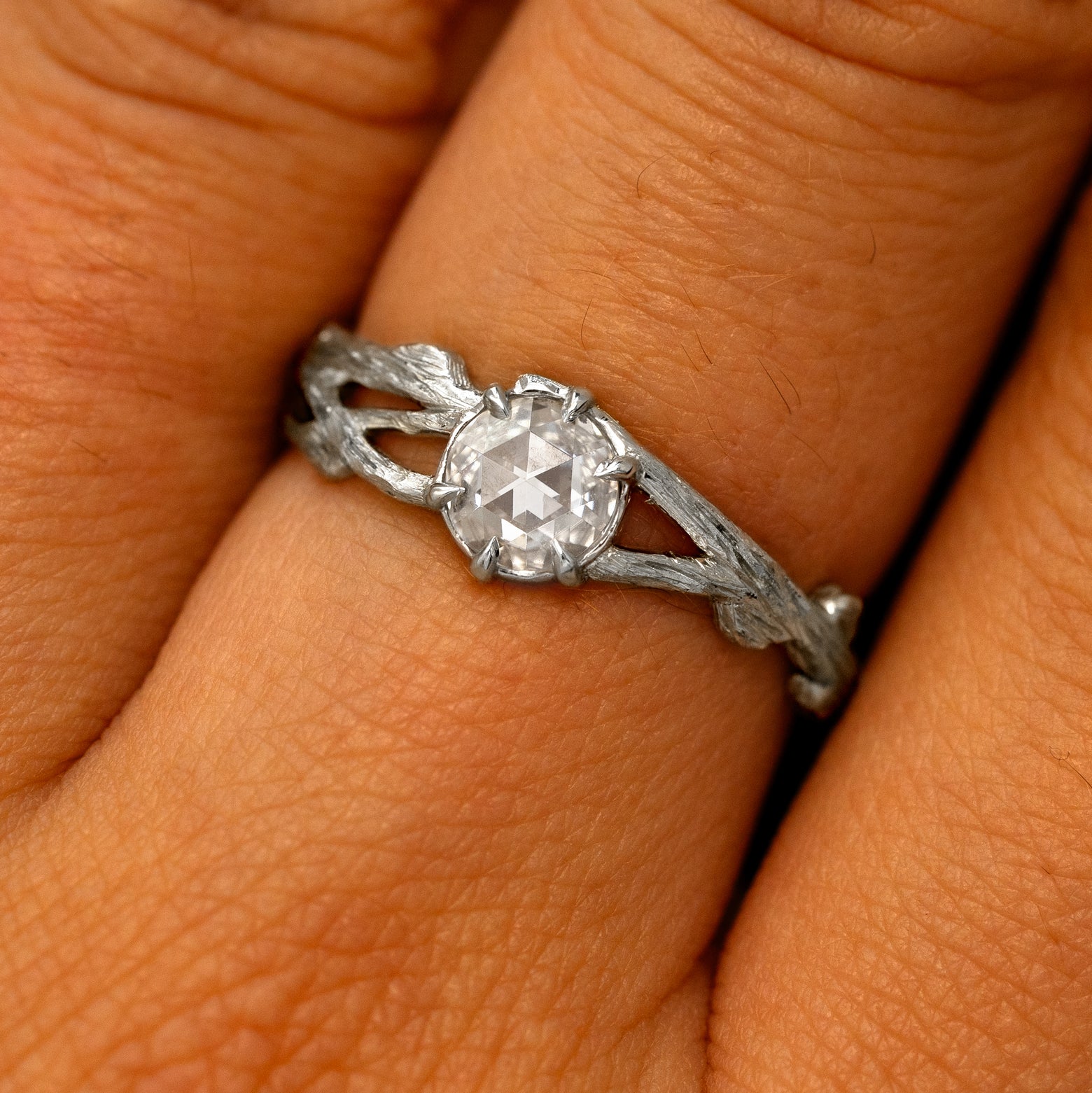 Close up view of a model's fingers wearing a platinum Moissanite Branches Ring