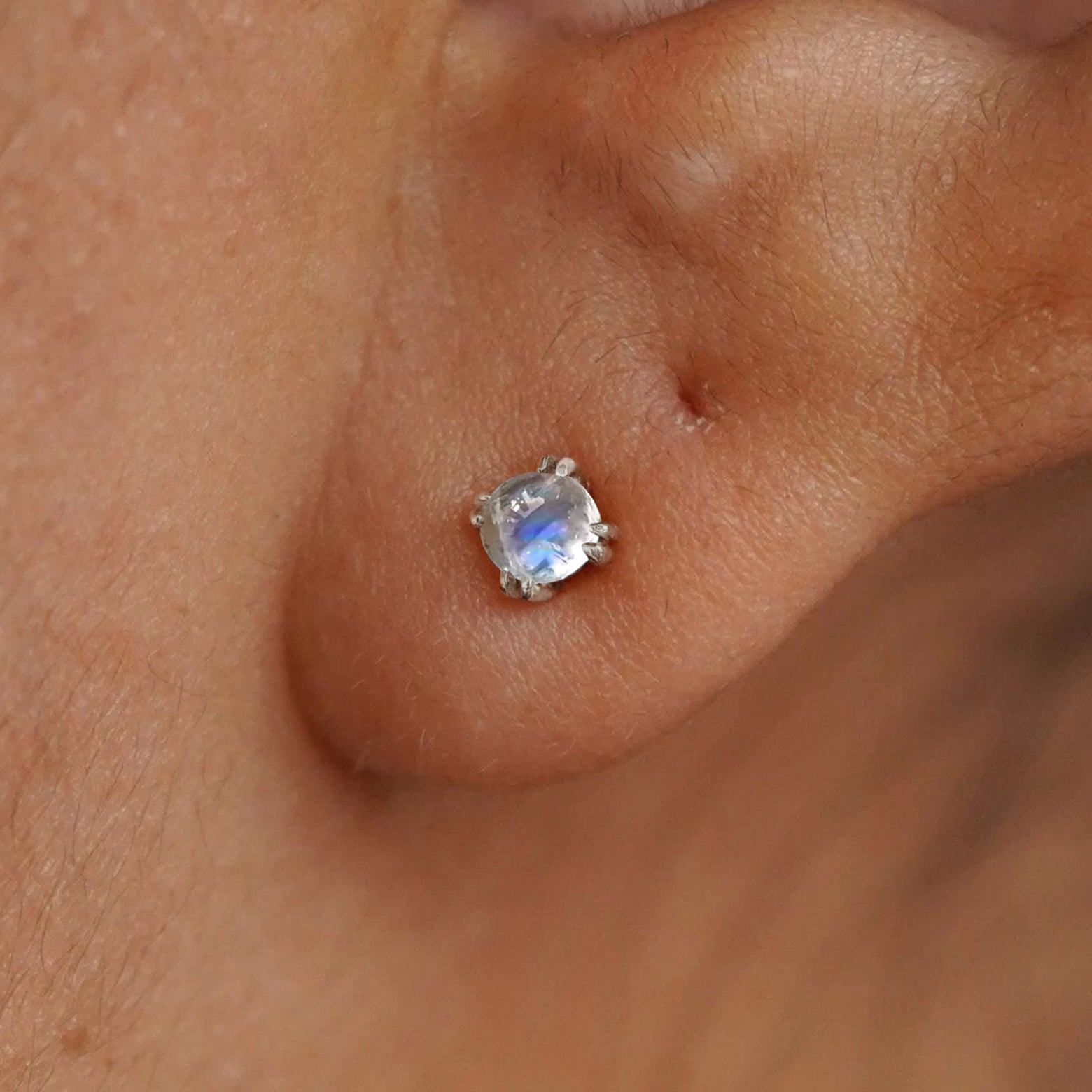 Close up view of a model's ear wearing a 14k white gold Moonstone Earring