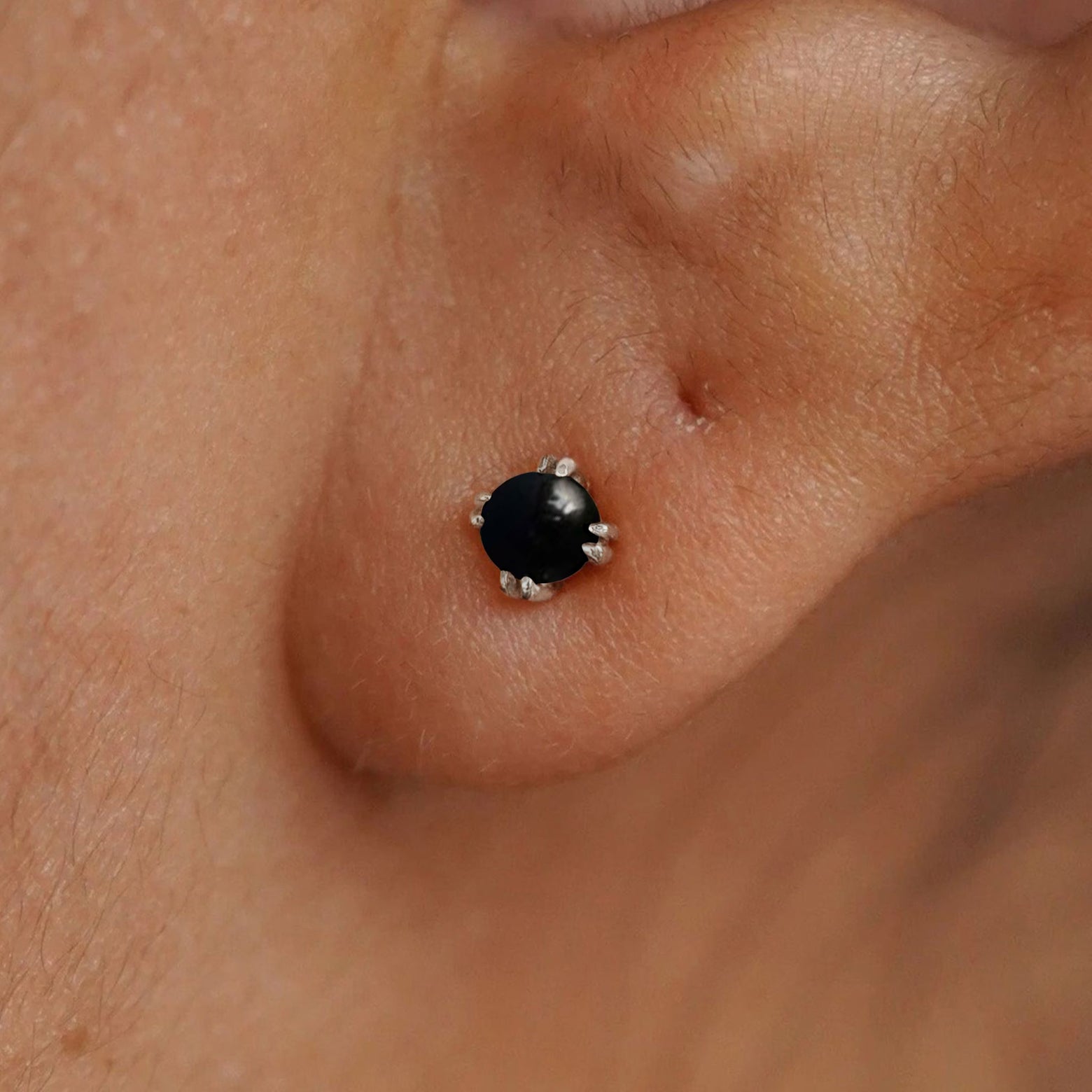 Close up view of a model's ear wearing a 14k white gold Onyx Earring