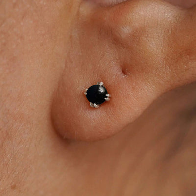 Close up view of a model's ear wearing a 14k white gold Onyx Earring