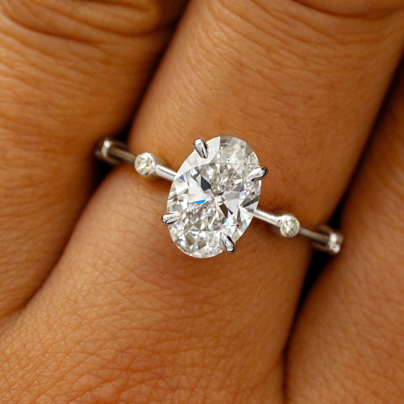 A solid 14k white gold Oval Lab Diamond Bubble Ring on a model's finger