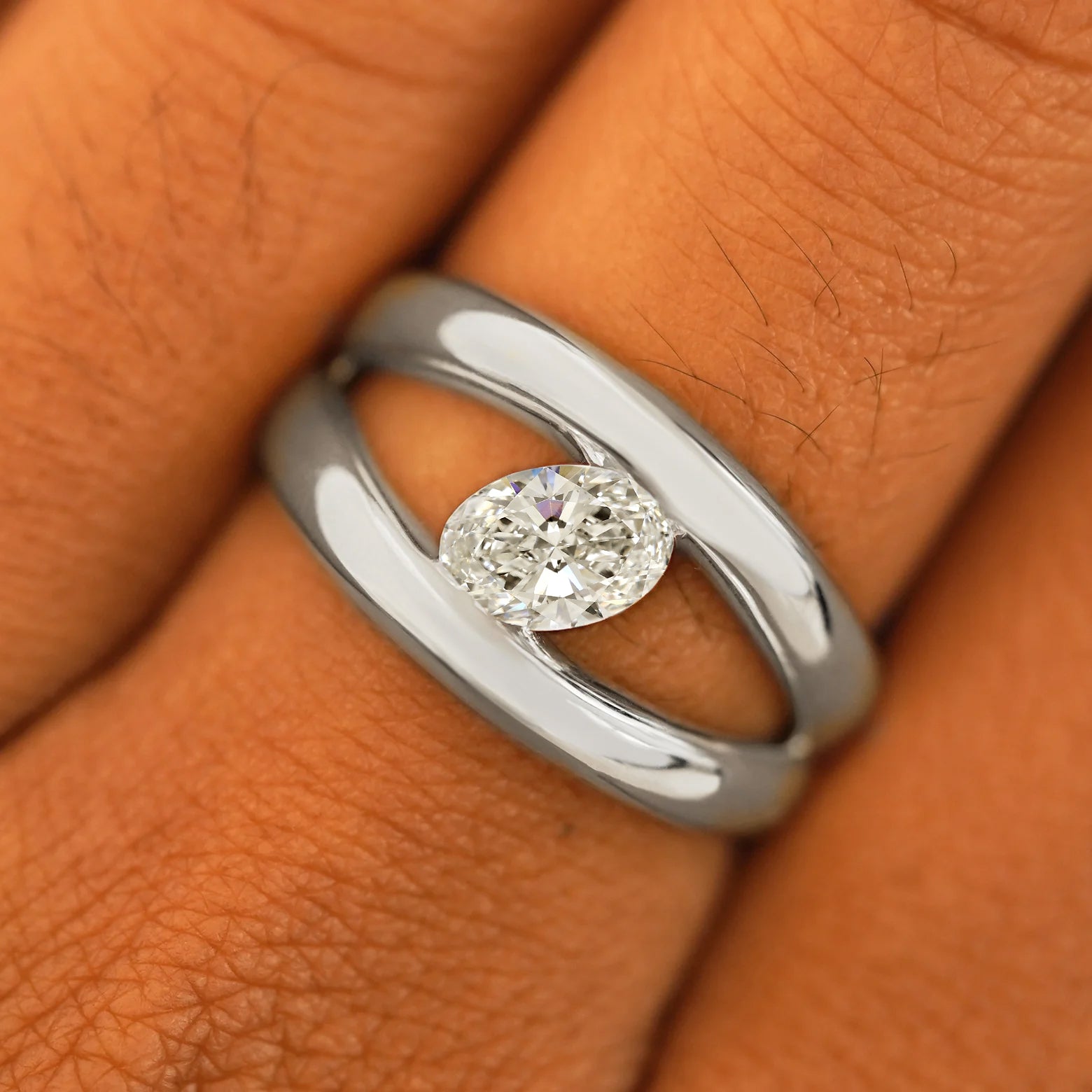 Close up view of a model's fingers wearing a 14k white gold Oval Lab Diamond Tension Ring