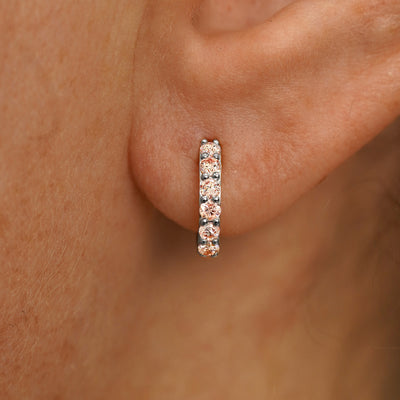 Close up view of a model's ear wearing a white gold Small Pink Lab Diamond Huggie Hoop
