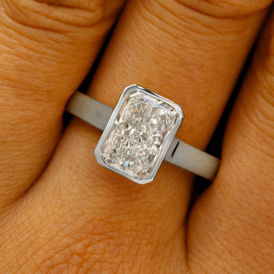 A solid 14k white gold Radiant Cut Lab Diamond Cathedral Ring on a model's finger
