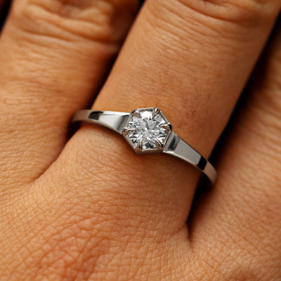 Close up view of a models fingers wearing a 14k white gold round diamond hexagon signet ring