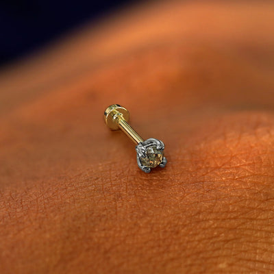 A solid 14k white gold Salt and Pepper Diamond Flatback Piercing resting on the back of a model's hand