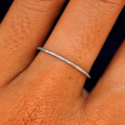 Close up view of a model's hand wearing a solid white gold Shimmer Ring