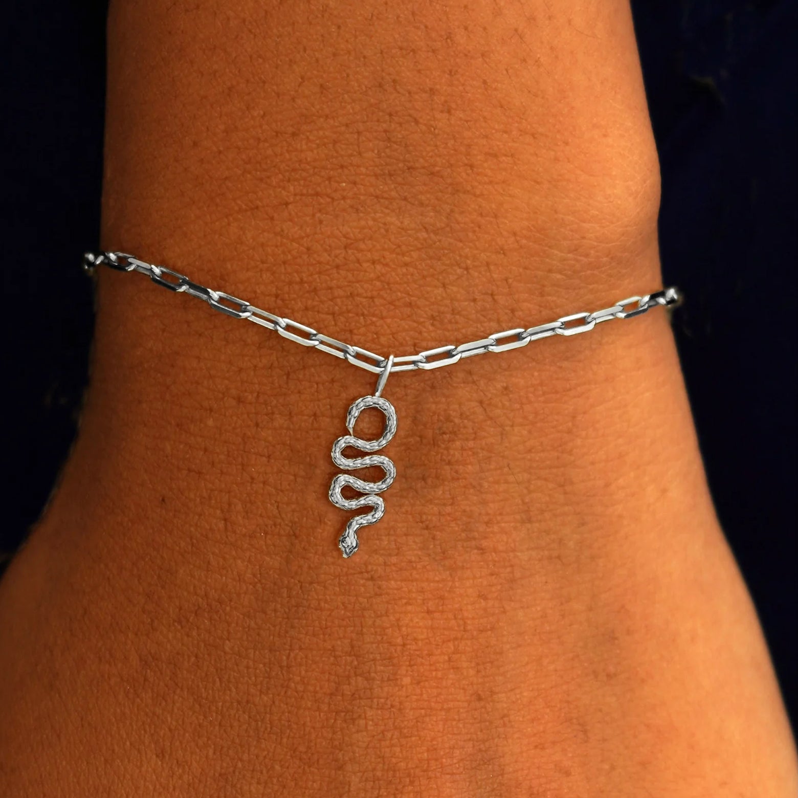 Close up view of a model's wrist wearing a white gold Snake Charm on a Butch Chain Bracelet