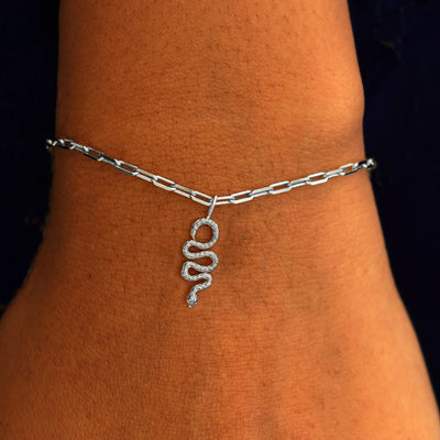 Close up view of a model's wrist wearing a white gold Snake Charm on a Butch Chain Bracelet