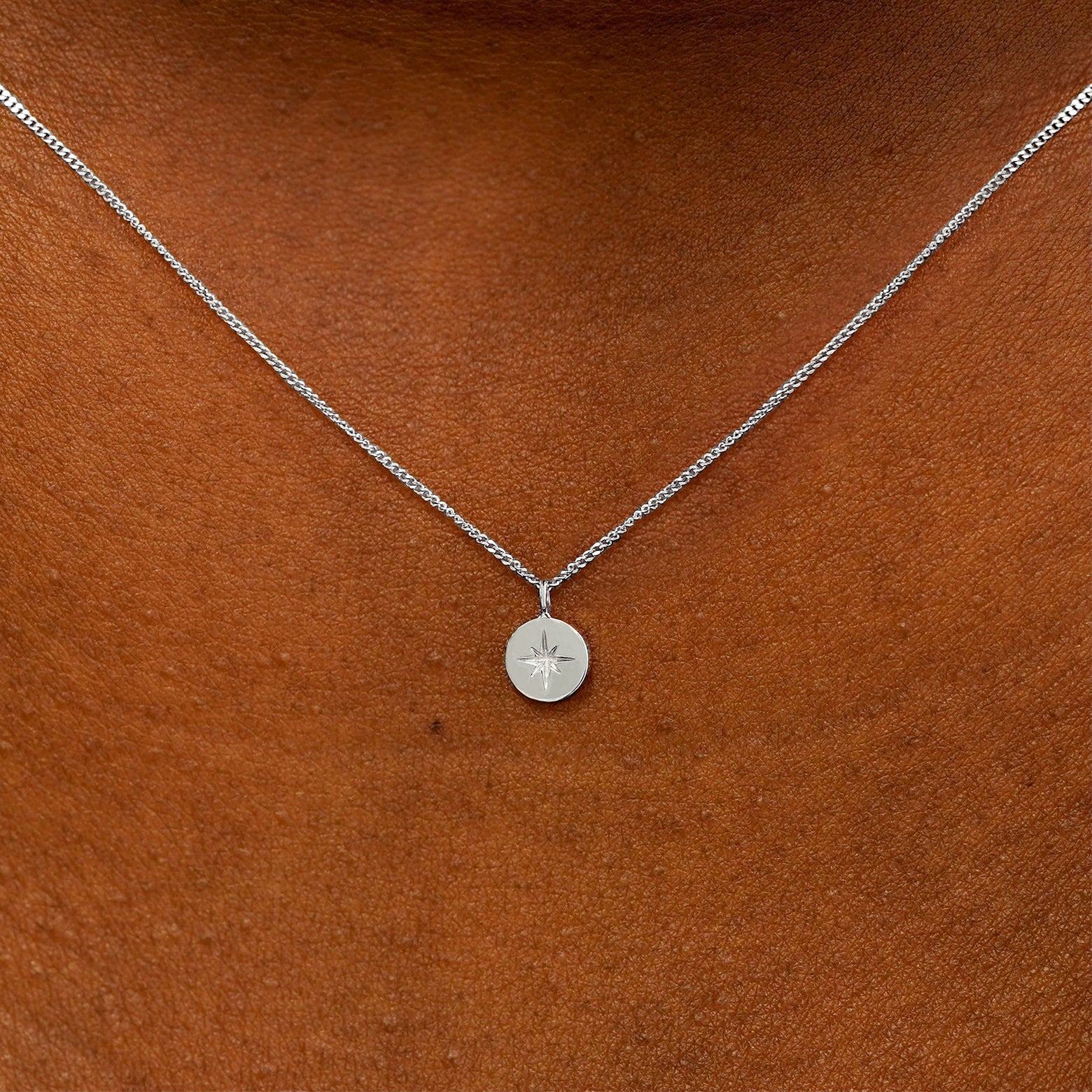 Close up view of a model's neck wearing a 14k white gold Star Disk Necklace