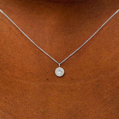 Close up view of a model's neck wearing a 14k white gold Star Disk Necklace