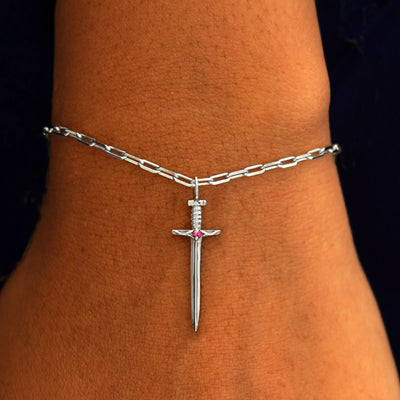 Close up view of a model's wrist wearing a white gold Sword Charm on a Butch Chain Bracelet