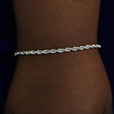 A model's wrist wearing a solid white gold Thick Rope Chain Bracelet
