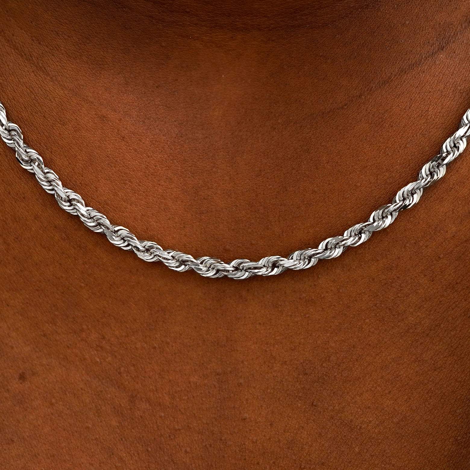 Close up view of a model's neck wearing white gold thick rope chain