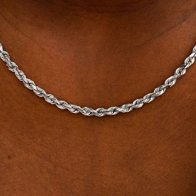 Close up view of a model's neck wearing white gold thick rope chain