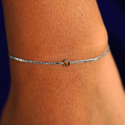 A model's wrist wearing a 14 karat white gold Tiger Eye Bracelet