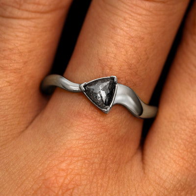 A model's hand wearing a 14k white gold Trillion Salt and Pepper Diamond Wavy Ring