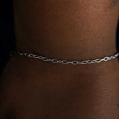 A model's wrist wearing a solid white gold Veren Bracelet