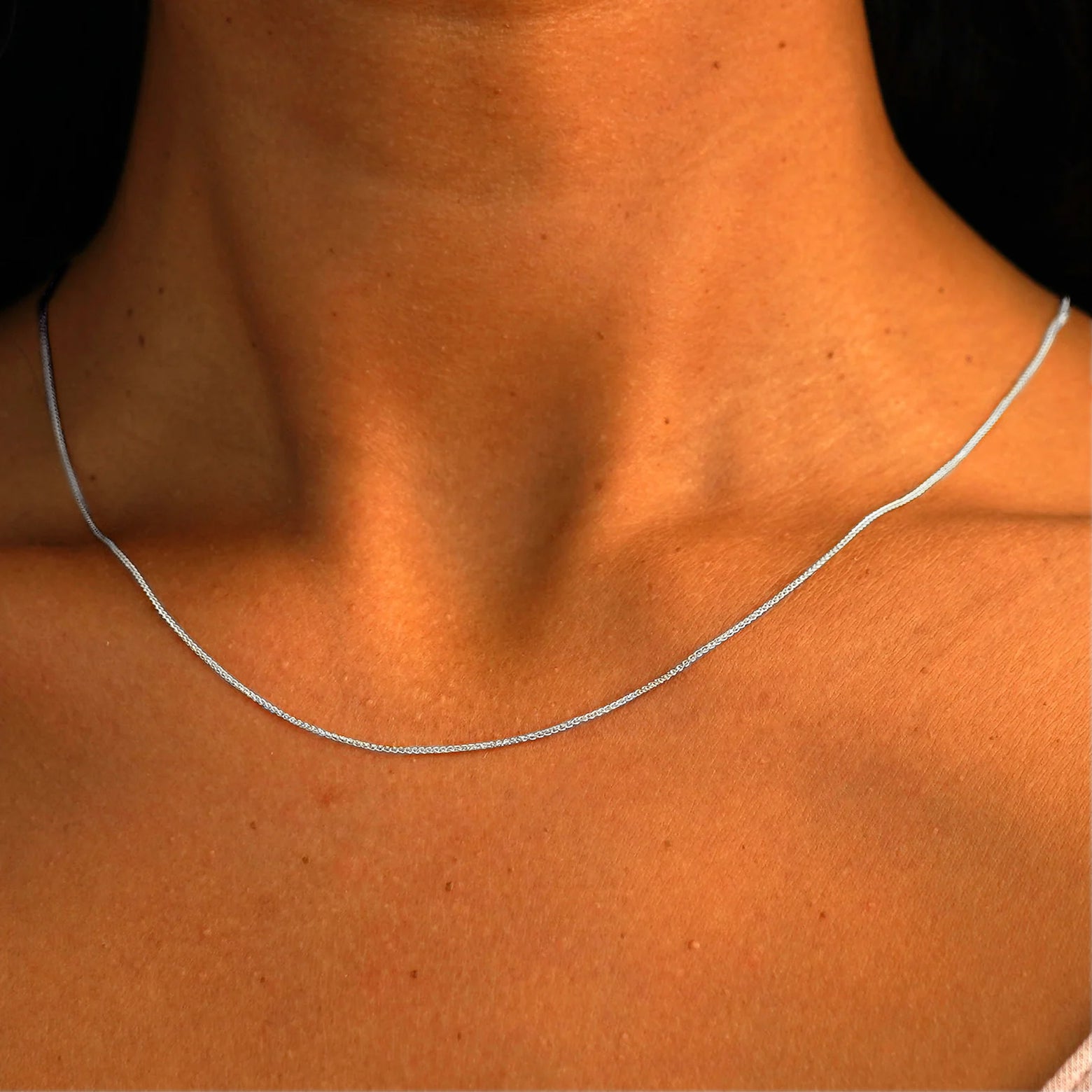 Close up view of a model's neck wearing a solid 14k white gold Wheat Chain