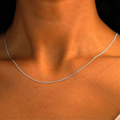 Close up view of a model's neck wearing a solid 14k white gold Wheat Chain