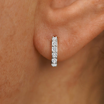 Close up view of a model's ear wearing a white gold Small Lab White Diamond Huggie Hoop