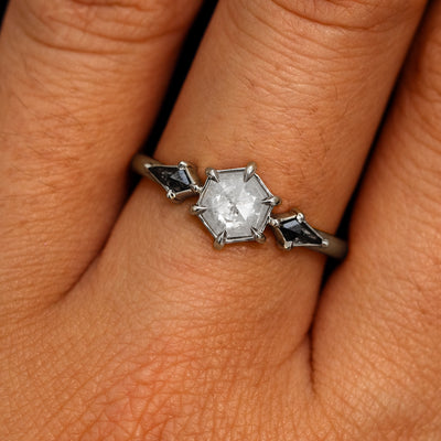 A model's hand wearing a 14k white gold Hexagon Salt and Pepper Diamond Black and White Ring