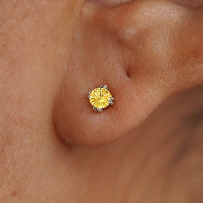 Close up view of a model's ear wearing a 14k white gold Yellow Diamond Earring