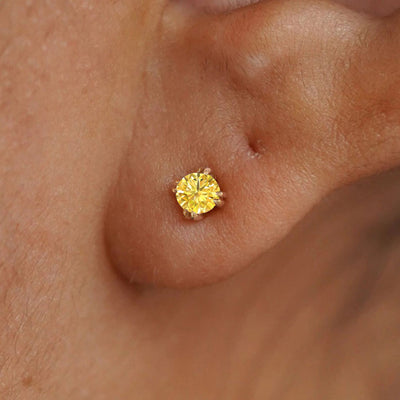 Close up view of a model's ear wearing a 14k yellow gold Yellow Diamond Earring