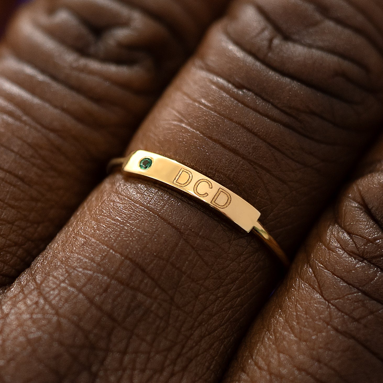 Close up  view of a model's fingers wearing a 14k yellow gold Gemstone Bar Ring