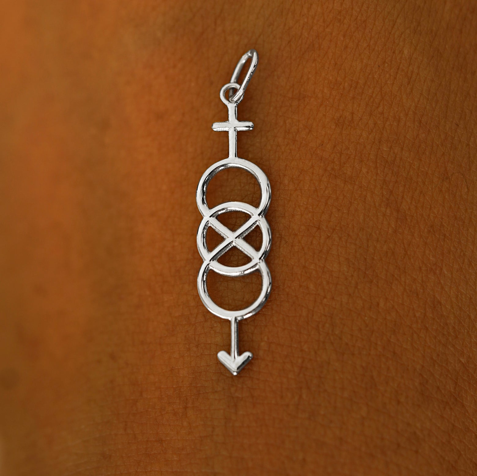 A solid 14k white gold Bisexual Symbol Charm resting on the back of a model's hand